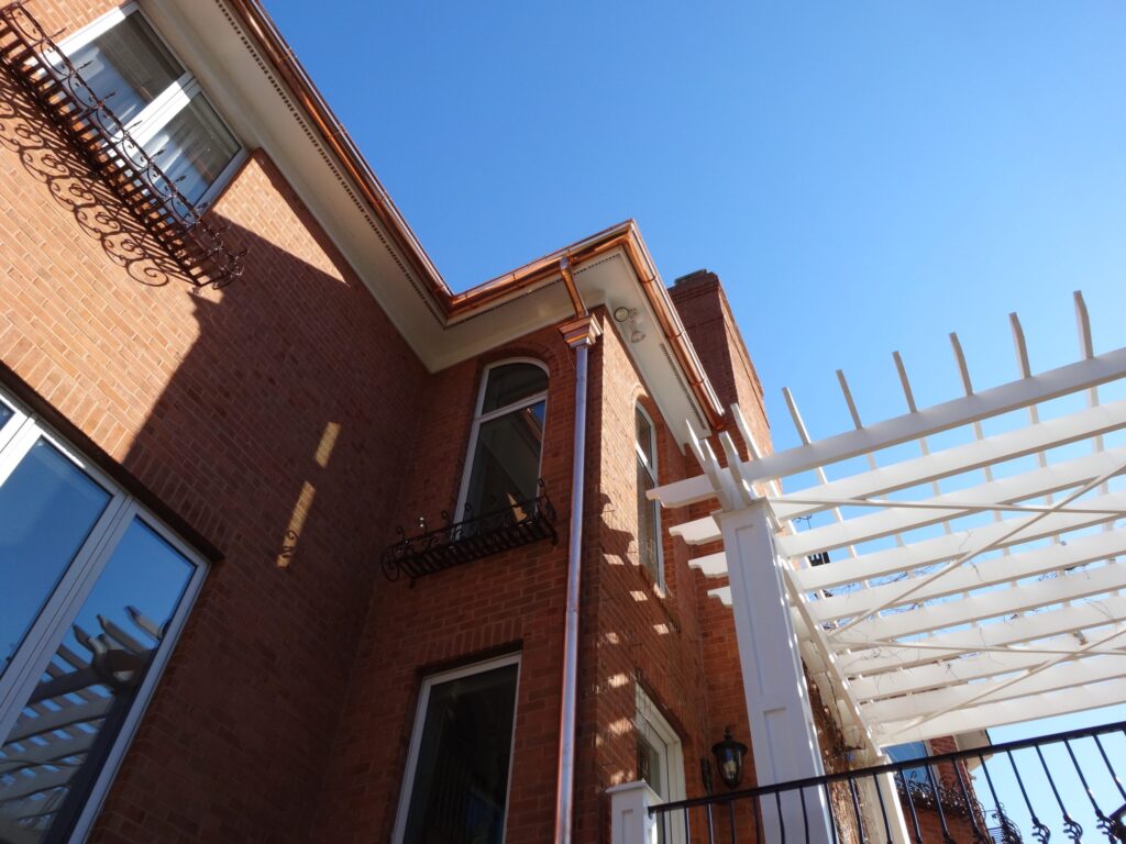 Copper gutter corner against white trim