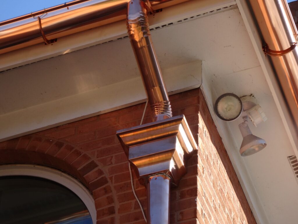 Copper gutter beside an arched window