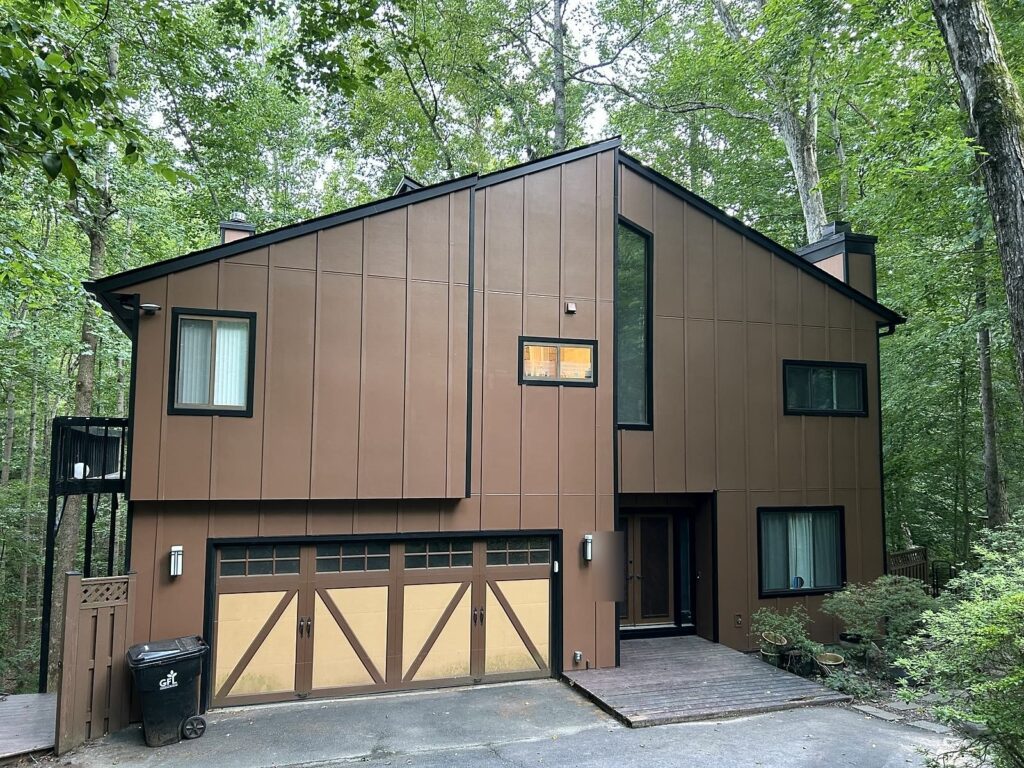 New vertical siding, dark trim and gutters on a wooded contemporary home in Manassas, VA, by Sunshine Contracting