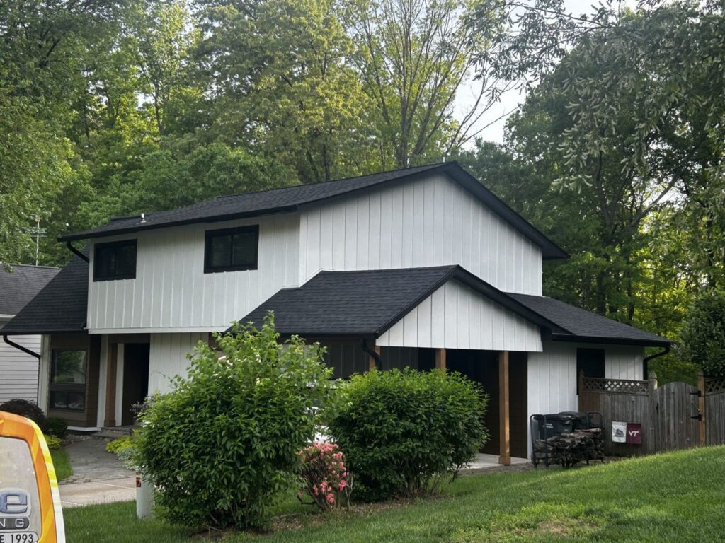 Springfield, VA home after James Hardie board and batten siding in Arctic White, black gutters and a GAF Charcoal roof