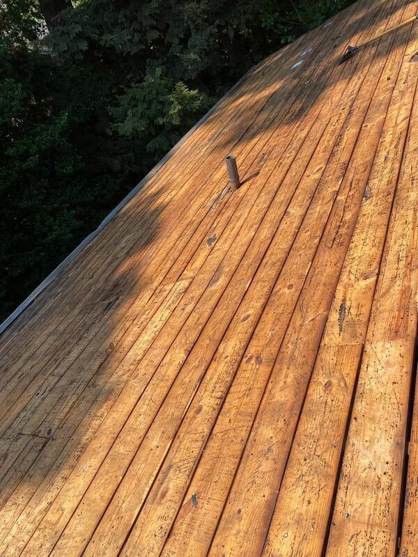 Original plank roof boards exposed during tear-off on an Arlington, VA home