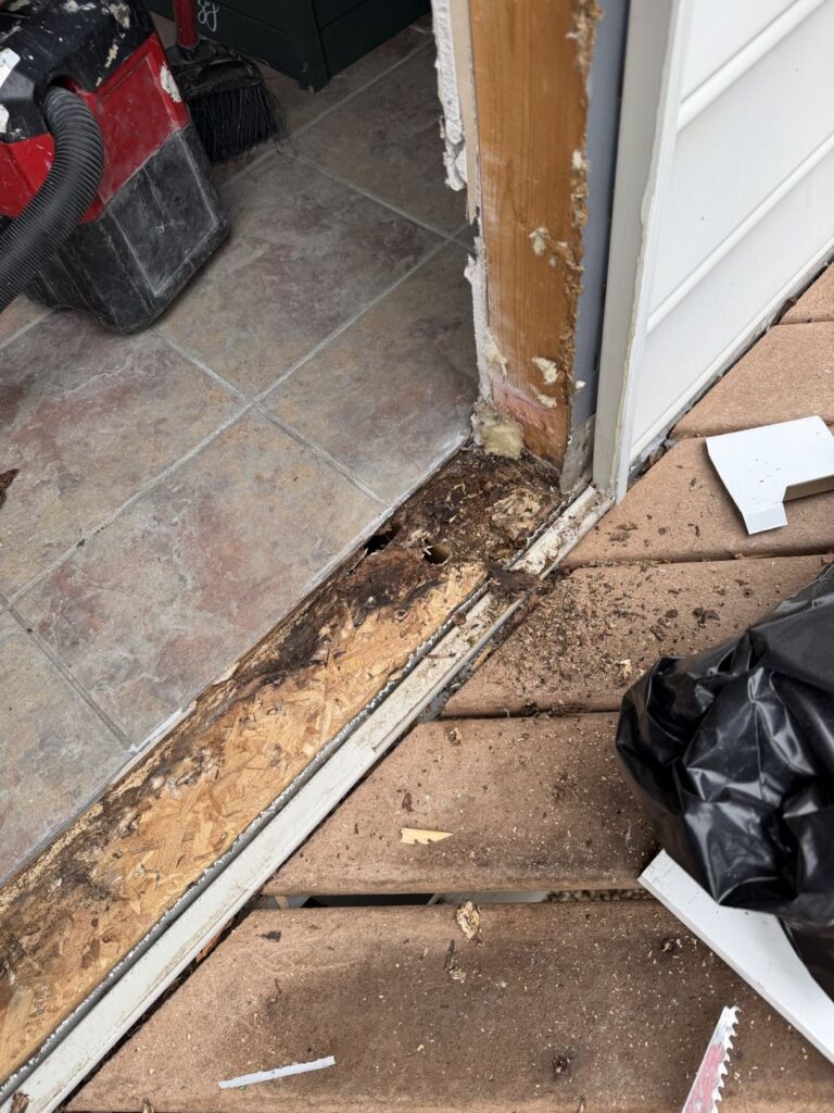 Fairfax Station, VA sun room doorway before replacement, with water damage under the old patio door sill