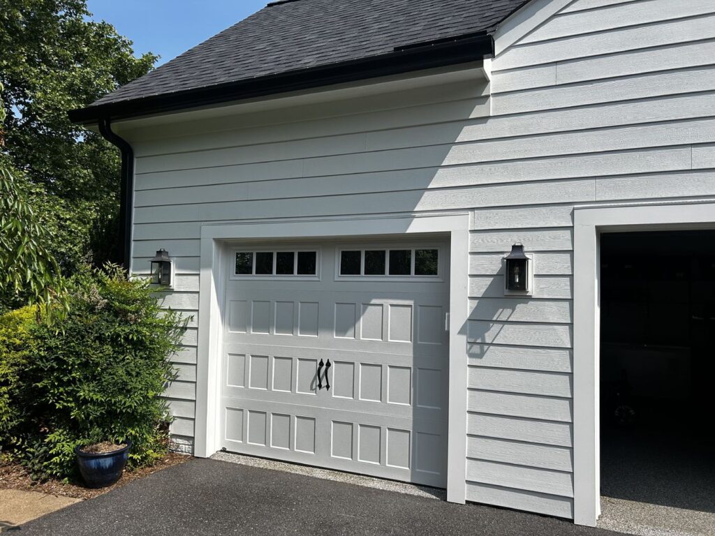 Garage wall of a Great Falls, VA home in new white James Hardie siding with new trim