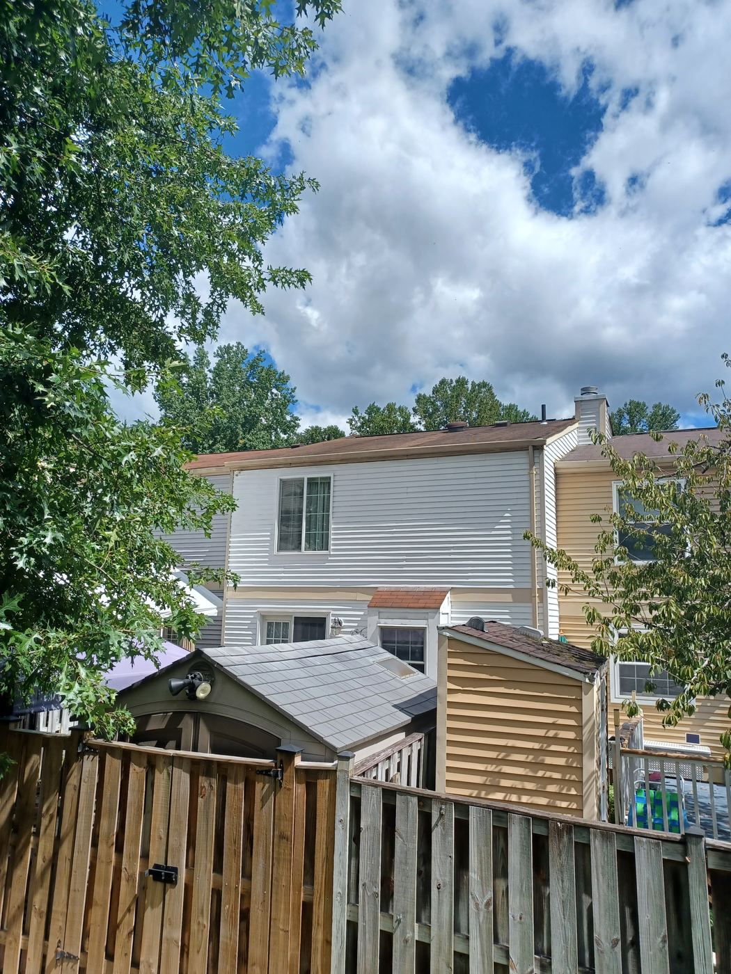 Rear of a Lorton, VA townhouse with its worn original roof before replacement
