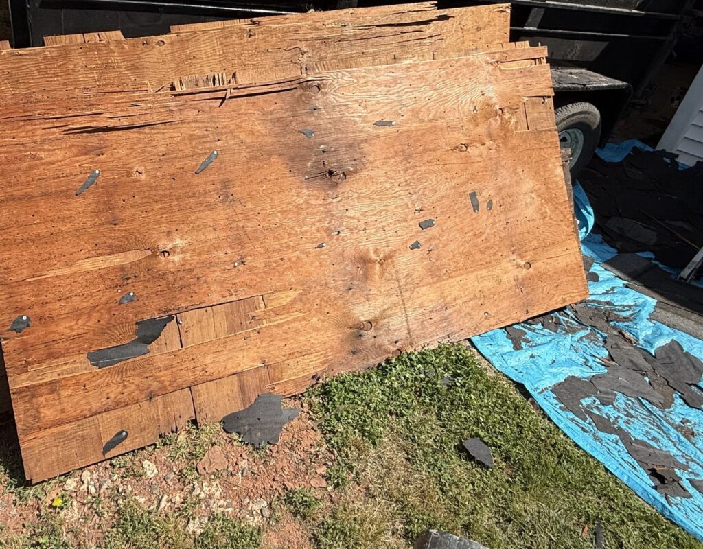 Old, damaged roof decking boards removed from a Manassas, VA home